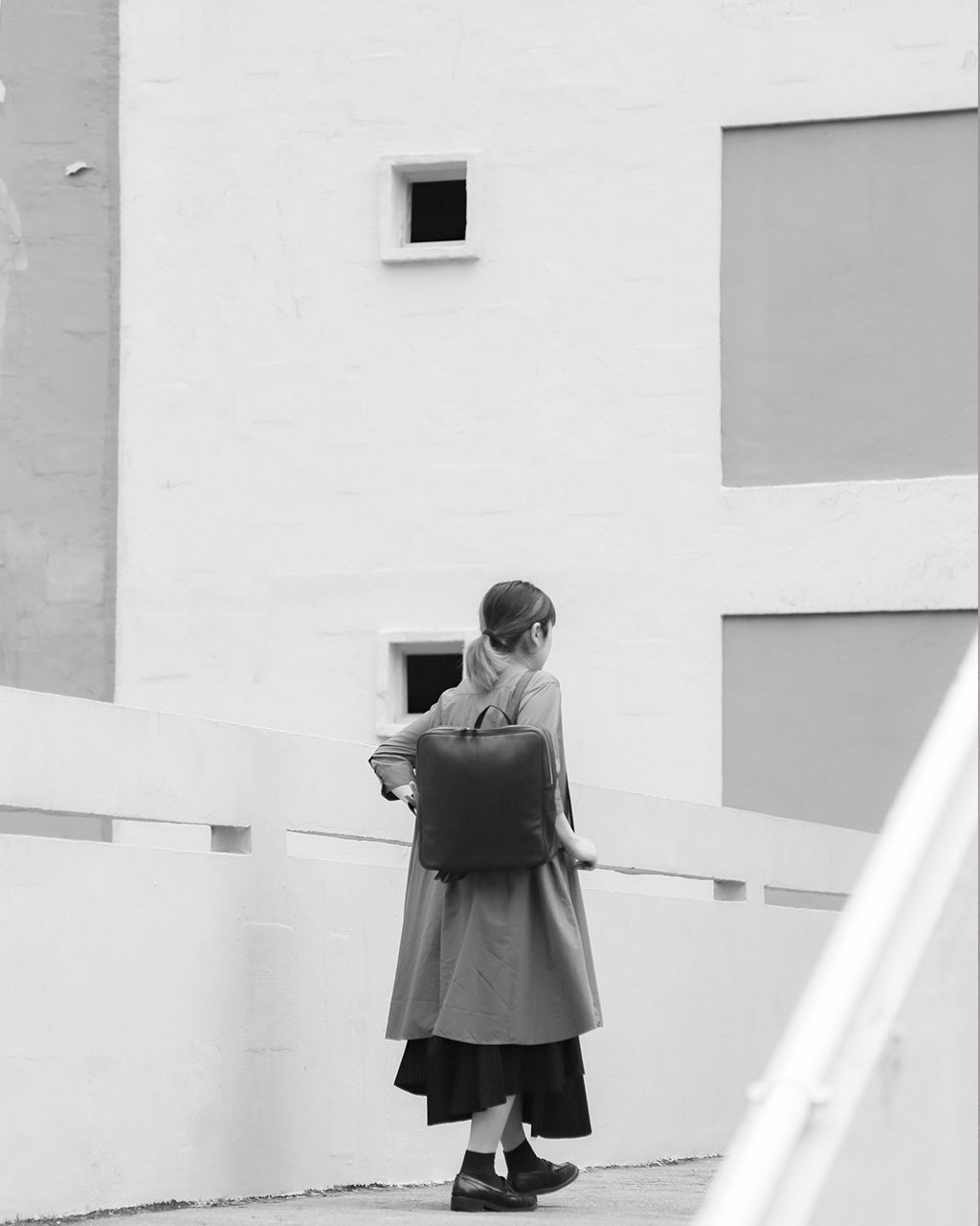black square leather backpack carrying by model