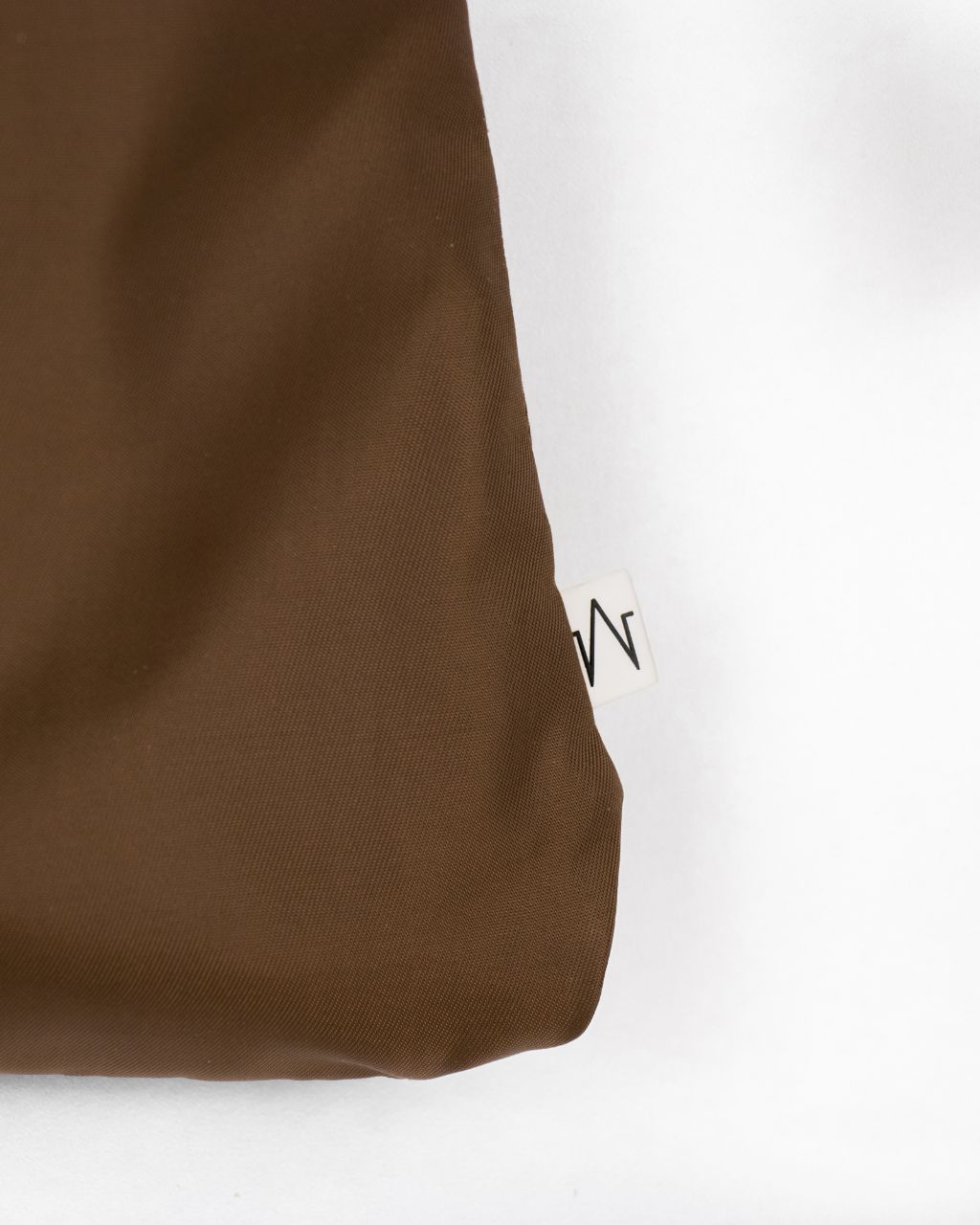 unisex work pocket in brown nylon logo tag close up
