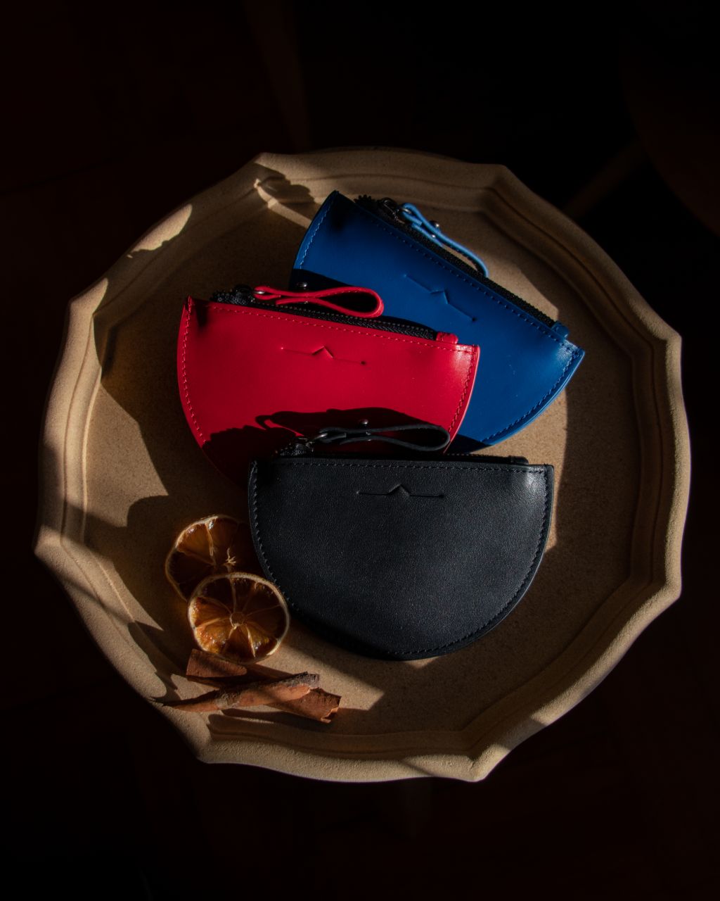 half moon mini leather pouch in 3 colour: blue, red and black with sun-dried orange slide in Christmas vibes