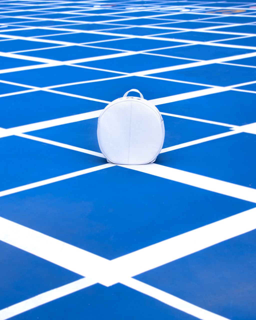 white round backpack on playground front 