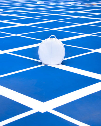 white round backpack on playground front 