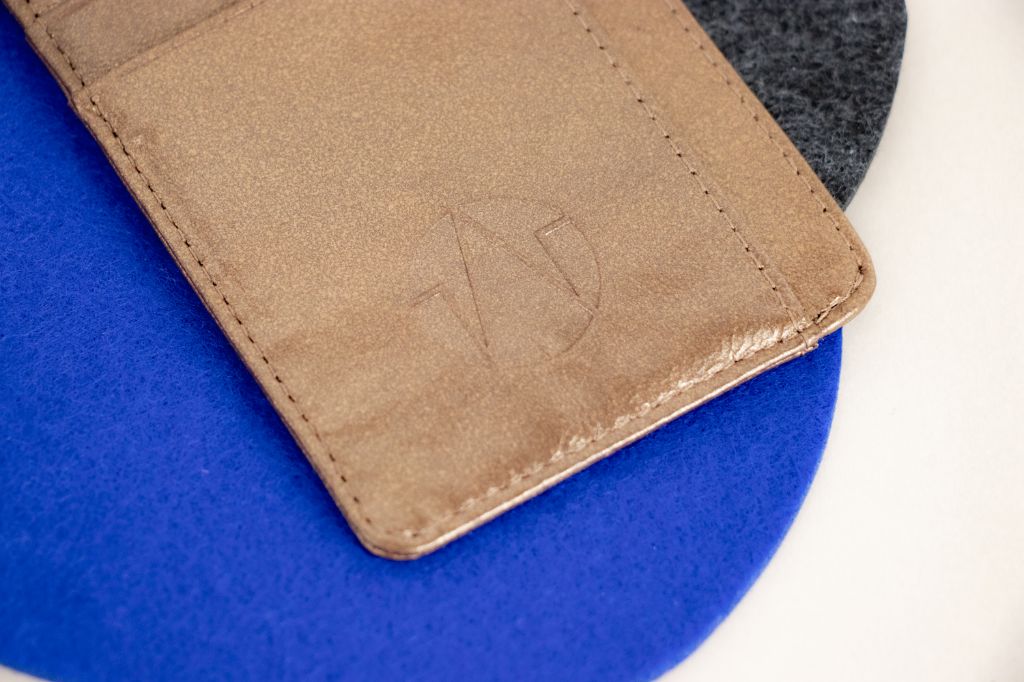 bronze cow leather card holder logo close up
