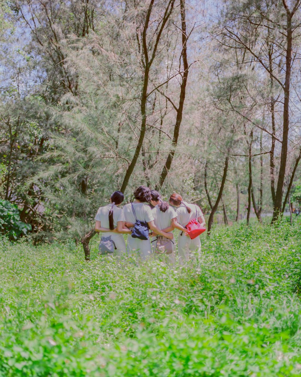 group of people wearing different colour bags on body